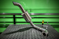 Stainless exhaust pipe on a green and black textured background