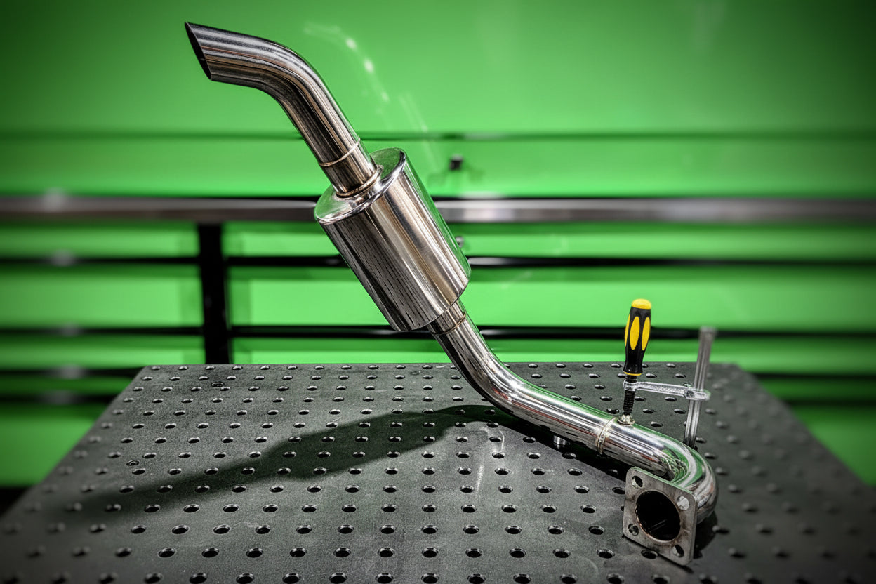 Stainless exhaust pipe on a green and black textured background